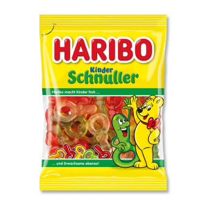 Un sachet haribo jaune avec le nounours haribo, remplis de tétine de couleurs différentes (jaune, rouge et orange)