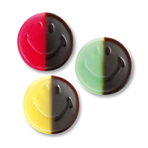 Bonbon visage souriant moitié réglisse et moitié fruits rouge, jeun et vert